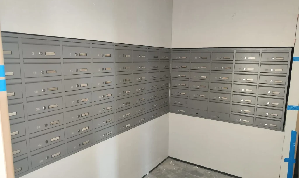 תיבות דואר מעוצבות לבית פרטי, מותקנות בקיר עם מספר תאים.