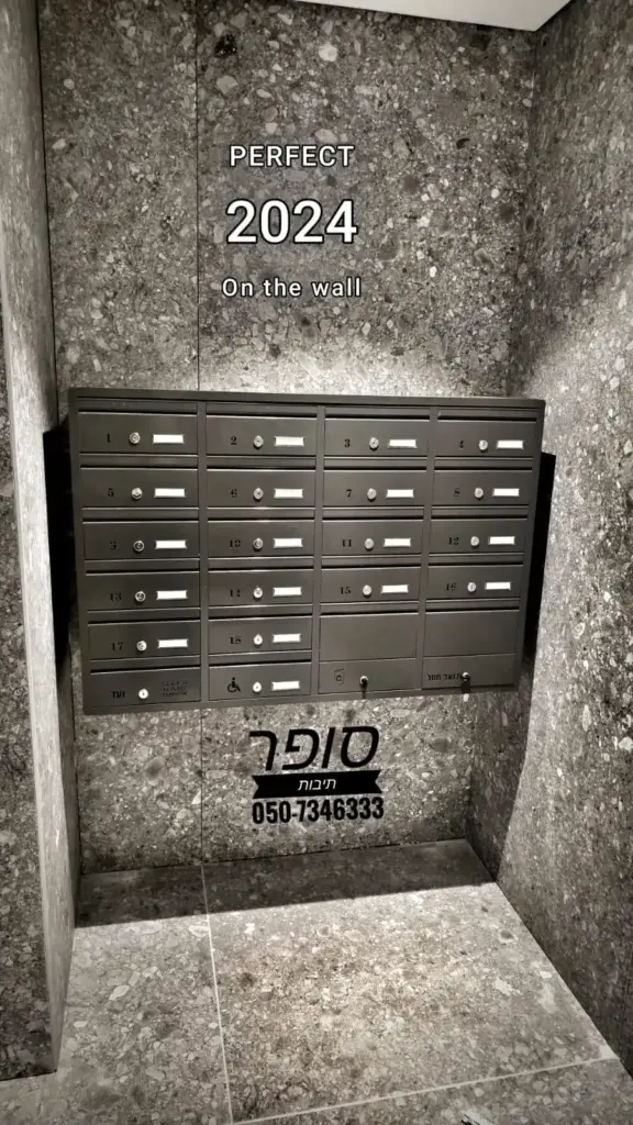 תיבות דואר מעוצבות לבית פרטי, מותקנות על הקיר, עם חריצים לשמות ומסגרת מתכתית.